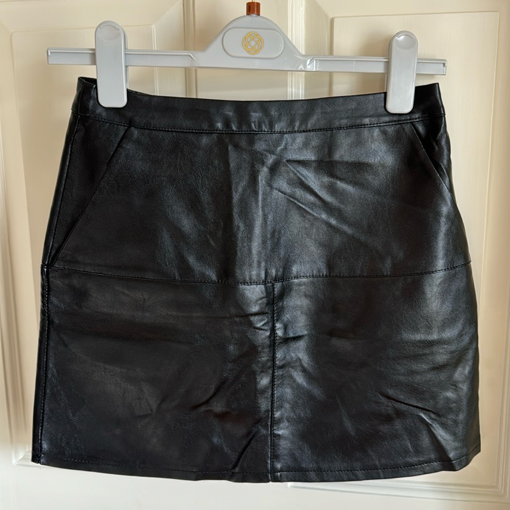 Black synthetic leather mini skirt by Mint Vanilla.